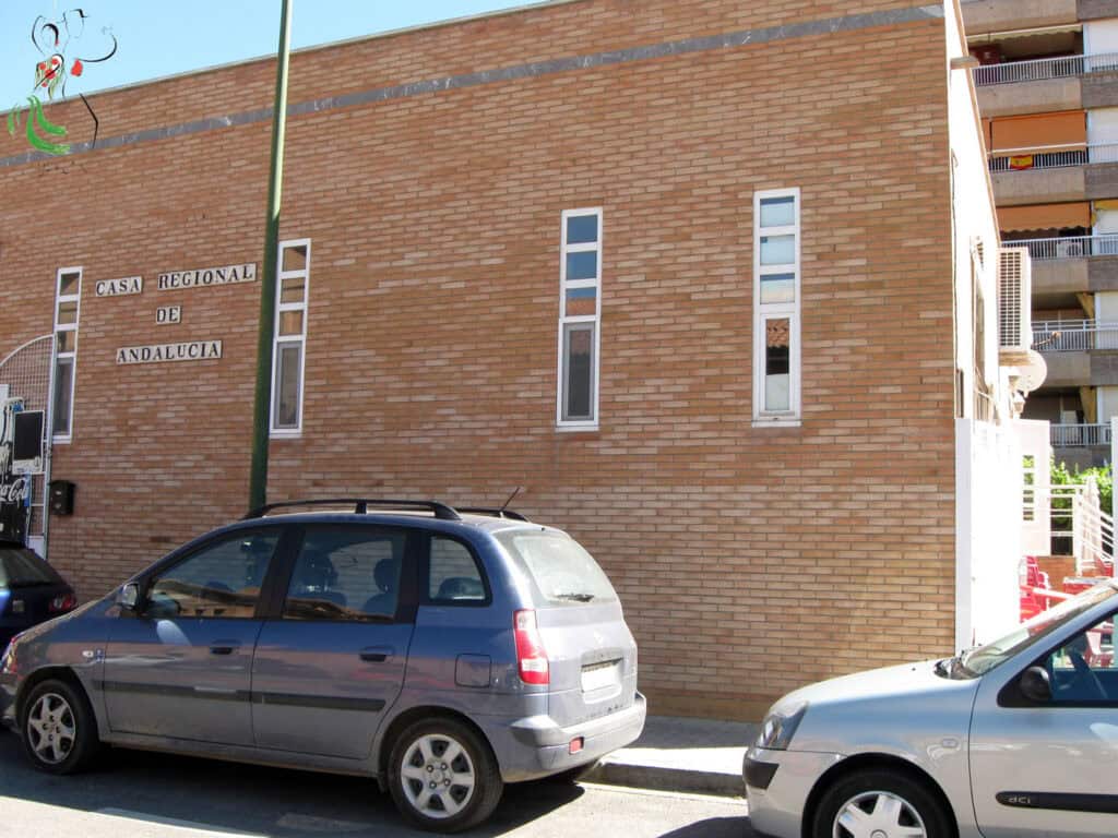 Casa Regional de Andalucía en Huesca, edificio con fachada de ladrillo y ventanas estrechas.